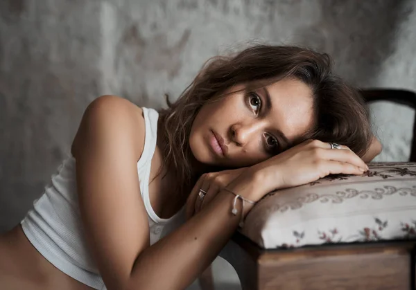 Retrato de uma bela mulher modelo colocar a cabeça em uma cadeira no quarto de hotel — Fotografia de Stock