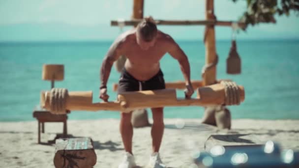 Fitness-Mann trainiert am Strand in Öko-Fitnessstudio — Stockvideo