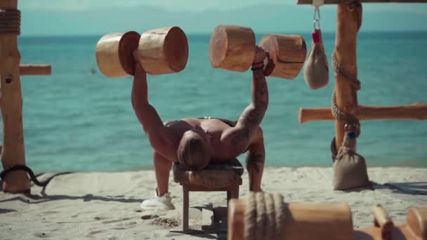 Fitness man training op het strand in Eco gym — Stockvideo