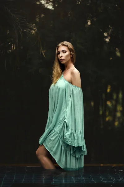 Yeşil elbise giyen güzel bir genç kadının moda fotoğrafı. — Stok fotoğraf