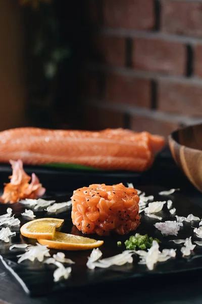 Tartare of salmon and chia seeds. Fresh salad served on black stone slate. — Stock Photo, Image