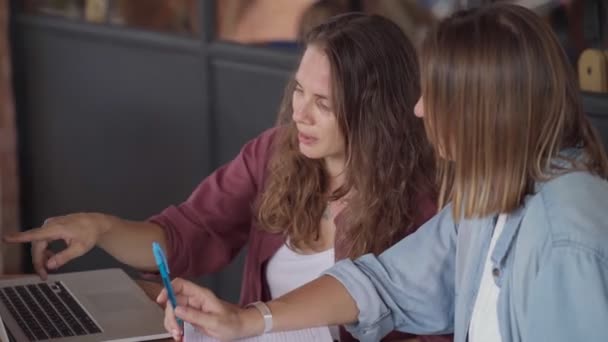 Mujeres felices trabajando junto con el portátil en la cafetería al aire libre — Vídeos de Stock