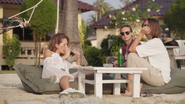 Friends sitting on the beach and enjoy talk — Stock Video