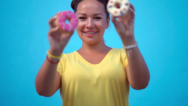 Vrouw bedekt haar ogen met donuts — Stockvideo