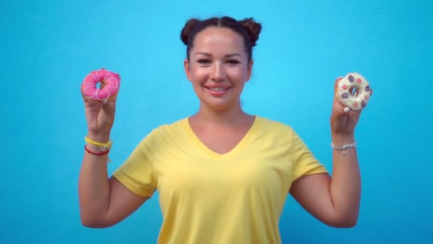 Mujer cubriéndose los ojos con rosquillas — Vídeos de Stock