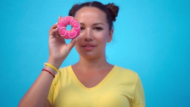 Vrouw bedekt haar ogen met donuts — Stockvideo