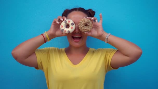 Woman covering her eyes with donuts — Stock Video