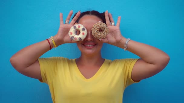 Woman covering her eyes with donuts — Stock Video