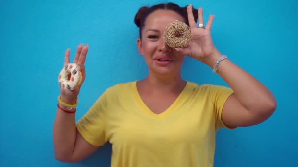 Frau bedeckt ihre Augen mit Donuts — Stockvideo