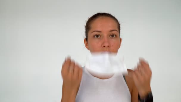 Jeune femme porte un masque de protection sur fond de mur blanc — Video