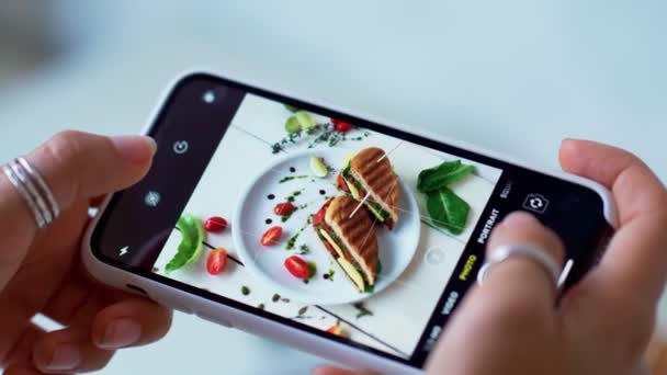 女性の手は現代のスマートフォンで食べ物の写真を撮る。閉鎖だ。4K. — ストック動画