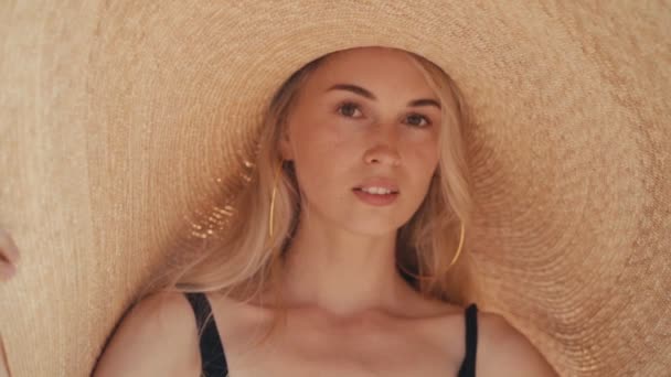 Bella ragazza indossa grande cappello estivo di paglia sulla spiaggia — Video Stock