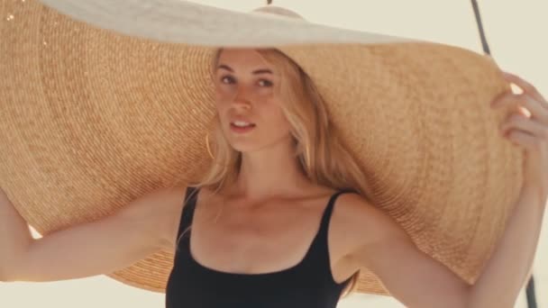 Mooi meisje dragen groot stro zomer hoed op het strand — Stockvideo