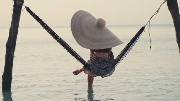 Bella ragazza indossa grande cappello estivo di paglia sulla spiaggia — Video Stock