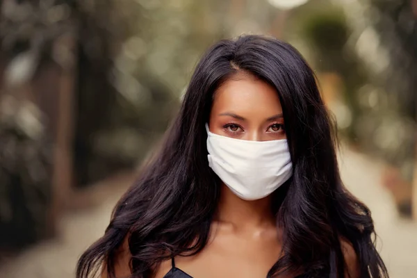 Красивая азиатка носит хирургическую маску защиты от вируса. Мода Азиатская модель с белой медицинской маской — стоковое фото