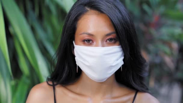 Belle femme asiatique portant une protection chirurgicale masque facial contre le virus. Mode modèle asiatique avec masque médical blanc — Video