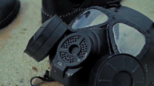 A black gas mask on the beach — Stock Video