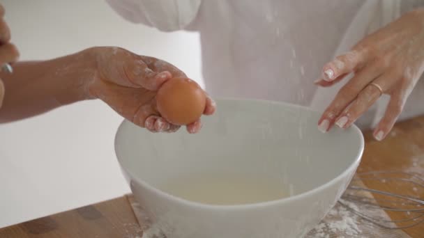 Close-up zicht op de handen van jonge vrouwelijke liefhebbende paar koken pannenkoeken of ontbijt in de keuken — Stockvideo