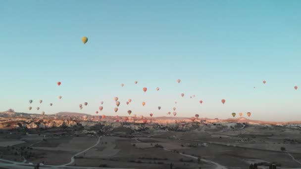 4K Légi felvétel Goreme-ről. Színes hőlégballonok röpködnek a völgyek felett. Híres város Cappadocia, Törökország. — Stock videók