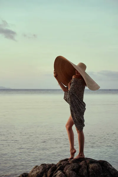 Belle fille portant un grand chapeau d'été de paille sur la plage — Photo