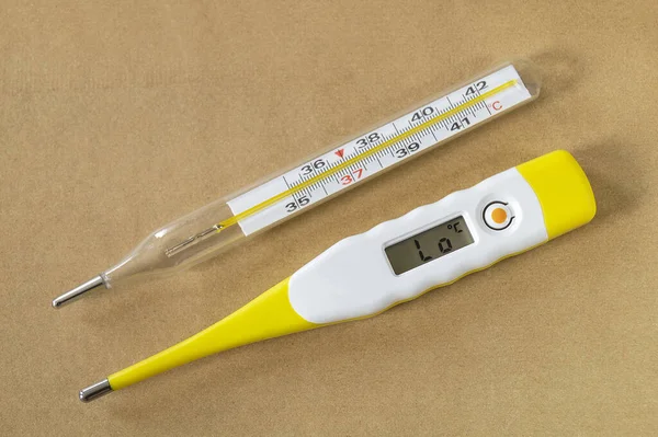 Vücudun sıcaklığını ölçmek için kullanılan alet. Gri arkaplandaki tıbbi araç.