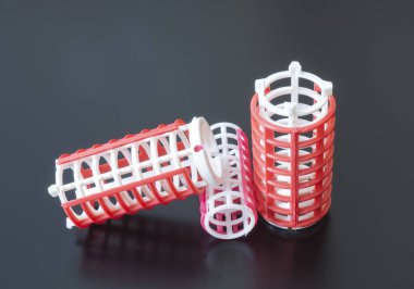 Siyah arkaplanda gül renginin bigudileri. Düz saç dalgası için bir araç