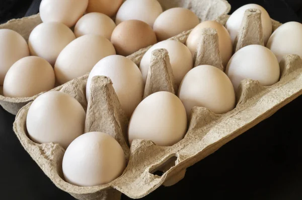 硫黄の鶏の卵は板紙から梱包する 暗い背景に飼料の新鮮な製品 — ストック写真