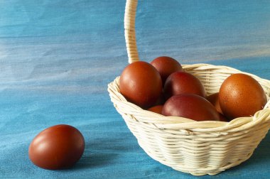 Kahverengi yumurta arka planda hafif sepette yatar. Paskalyanın dini bayramı.