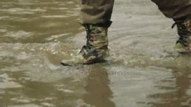 Bir adam haki botlarla gider