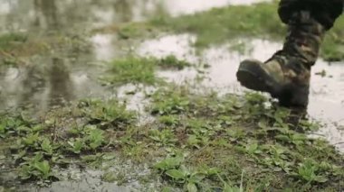 Bir adam ordu botlarla gider