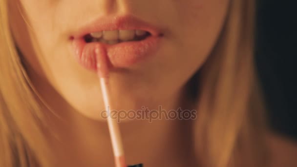 La donna si dipinge le labbra con il rossetto. Bella ragazza. primo piano — Video Stock