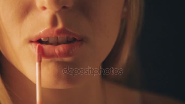 Schönes Mädchen bemalt Lippen mit rotem Lippenstift. Weibchen bemalt ihre Lippen. Nahaufnahme — Stockvideo