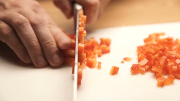 Man handen gesneden rode paprika's op een snijplank. Het concept van een gezond dieet — Stockvideo