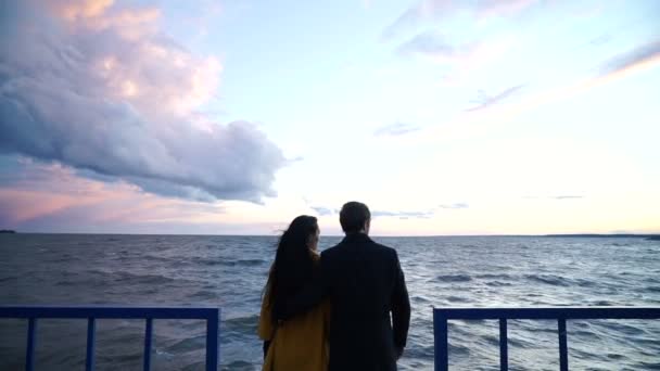 Man shows his girl beautiful landscape, couple spends time on pier — Stock Video