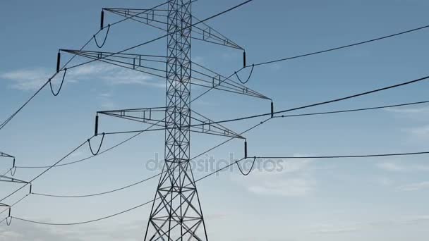 Високовольтна електрична вежа та лінії електропередач під прекрасним небом. петля — стокове відео