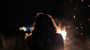 Kız kendini ateşle ısınıyor. kişi büyük yangın arka planı