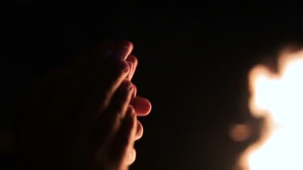Pár se drží ruce u táborového ohně v noci. Večírek s táborák s přáteli — Stock video
