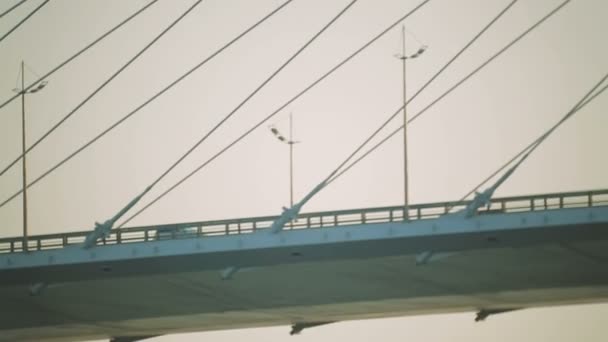 Autos fahren die Brücke an. Pylonen der Brücke vor dem Hintergrund des Sonnenuntergangs — Stockvideo