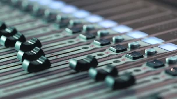 Audio mixer in a studio, the automatic knobs moving up on console. Close-up DOF — Stock Video