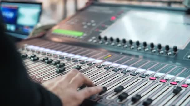 Hand of the sound producer. Controls of video and audio mixing console. close up — Stock Video