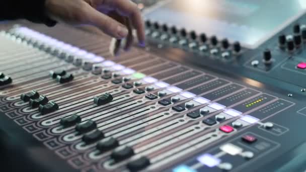 Audio engineer bezig met een professionele console, moving faders, muziek mixen — Stockvideo