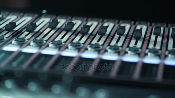 Mixer de áudio em um estúdio, os botões automáticos se movendo para cima no console. Plano geral DOF — Vídeo de Stock