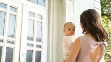 Güzel anne sarılma ve vermek kisses arka bahçesinde, neşeli bebek için