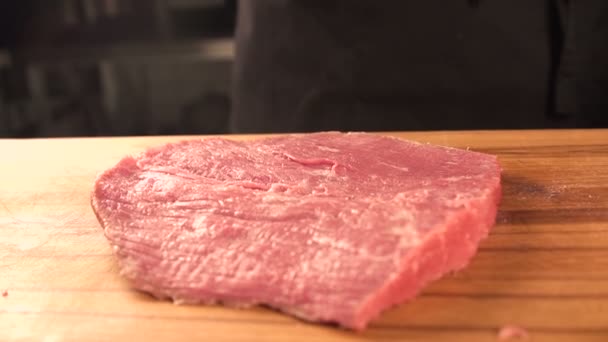 Cocinar es cocinar carne. Carne fresca cruda sobre la mesa. chef vence a la carne de res — Vídeos de Stock