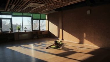 Bir kadın kişi asanas Örtüleme Yog Studio üzerinde yapıyor