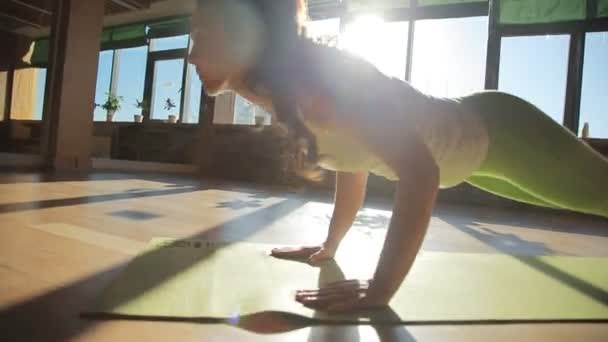 Un entrenador personal haciendo asanas se acuesta sobre estera — Vídeo de stock