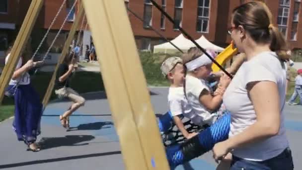 Duas mães adultas andando e alegria com as crianças no dia ensolarado da primavera — Vídeo de Stock