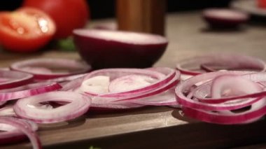 Kesme tahtası slowmo ile kırmızı soğan halkaları düştü