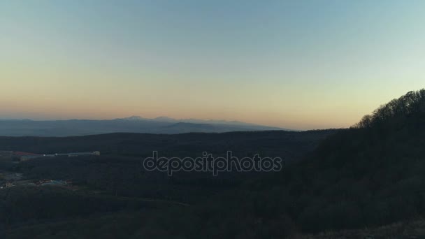 Pohled shora na západ slunce nad zelený les a hory — Stock video