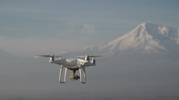Quadcopter flyr høyt over snødekte fjell – stockvideo